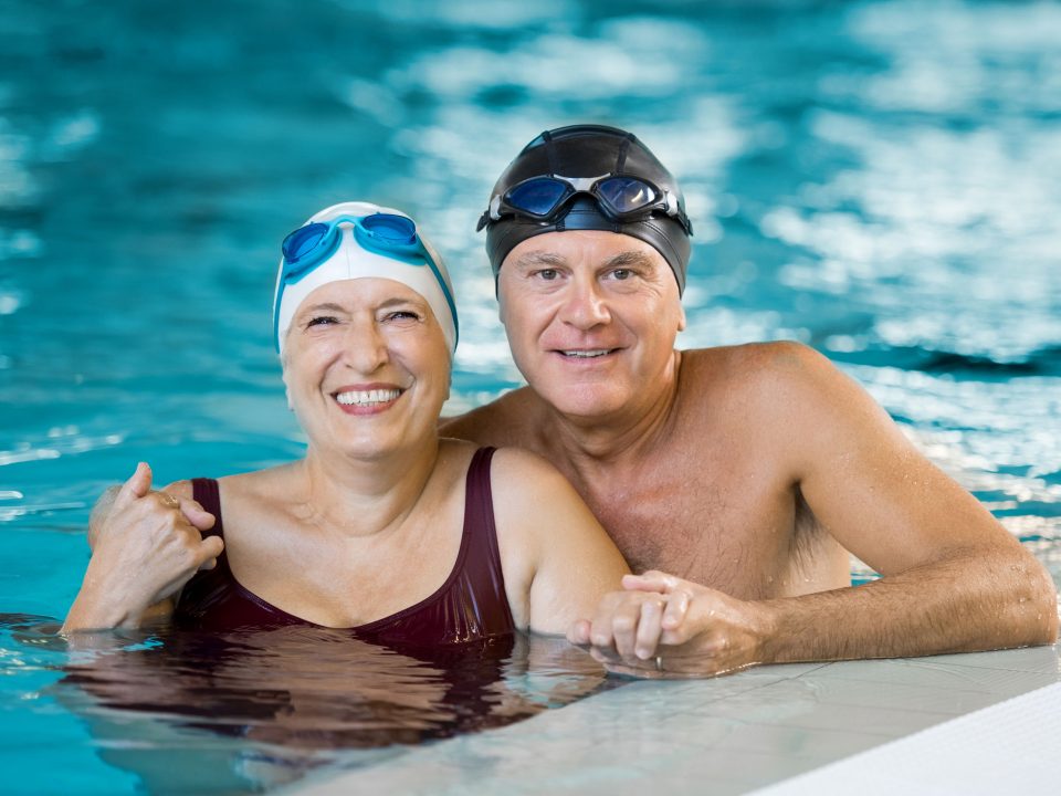 senior couple smiling while getting ready for an aquatics class
