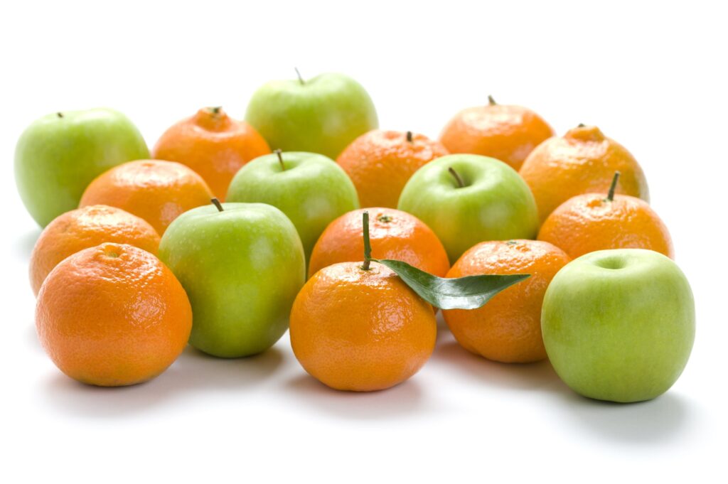 oranges and Granny Smith apples on a white background