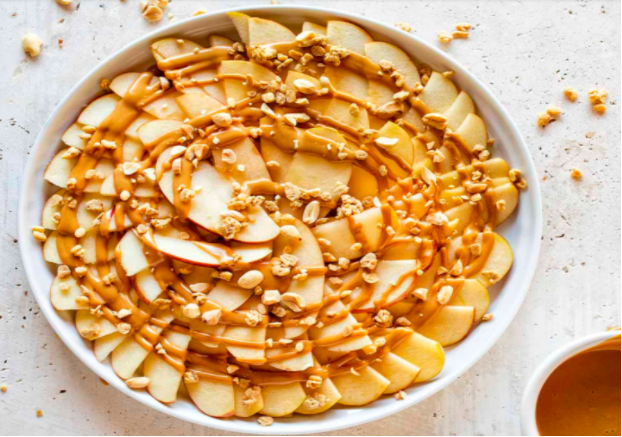 apple nachos with drizzled peanut butter, granola, and peanuts
