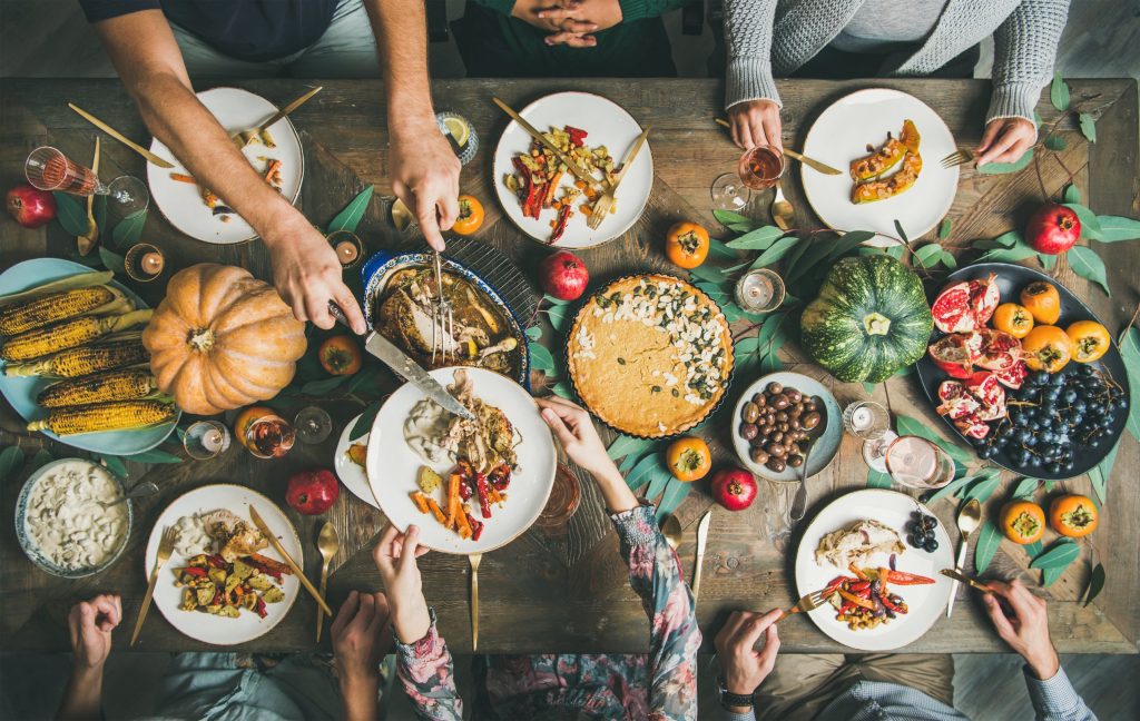 Family eating together at a dinner table dressed in autumn decor.