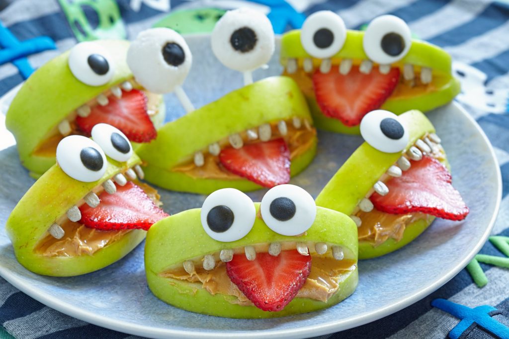 Monster mouth treats made out of apples, strawberries, and peanut butter.