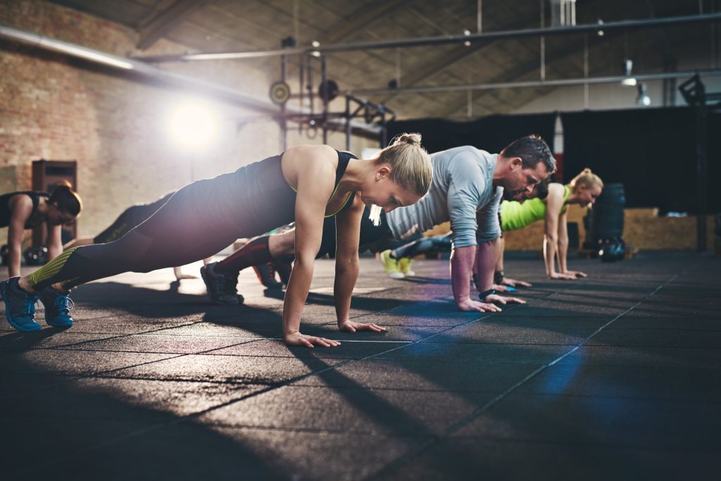 Adults working out, performing planks.