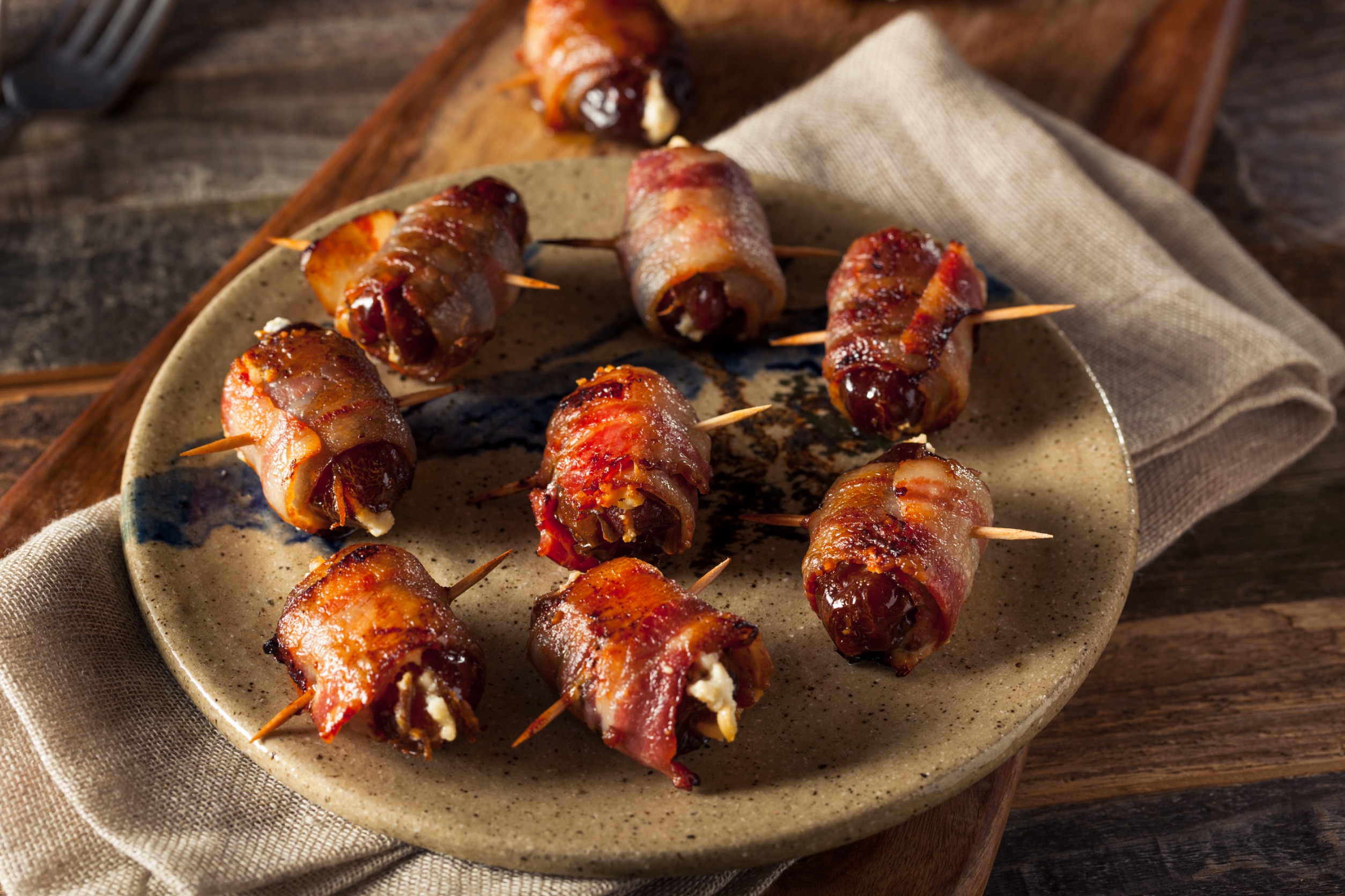 Bacon-wrapped dates with goat cheese on a plate.