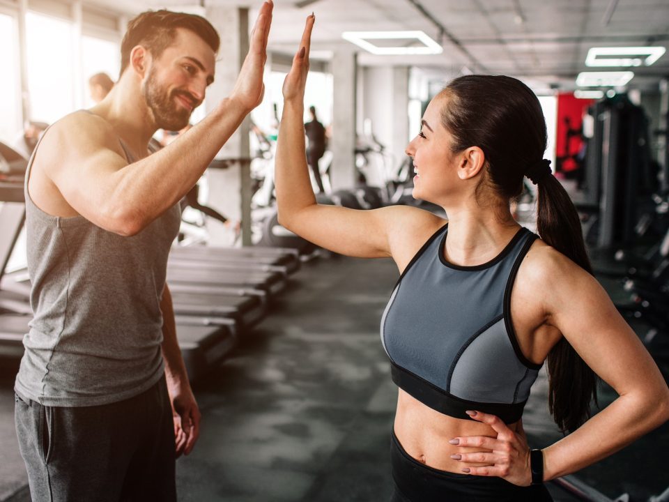 Couple giving each other a high five after a partner workouts.