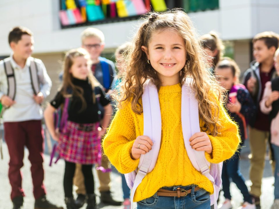 Girl wearing a backpack with her classmates