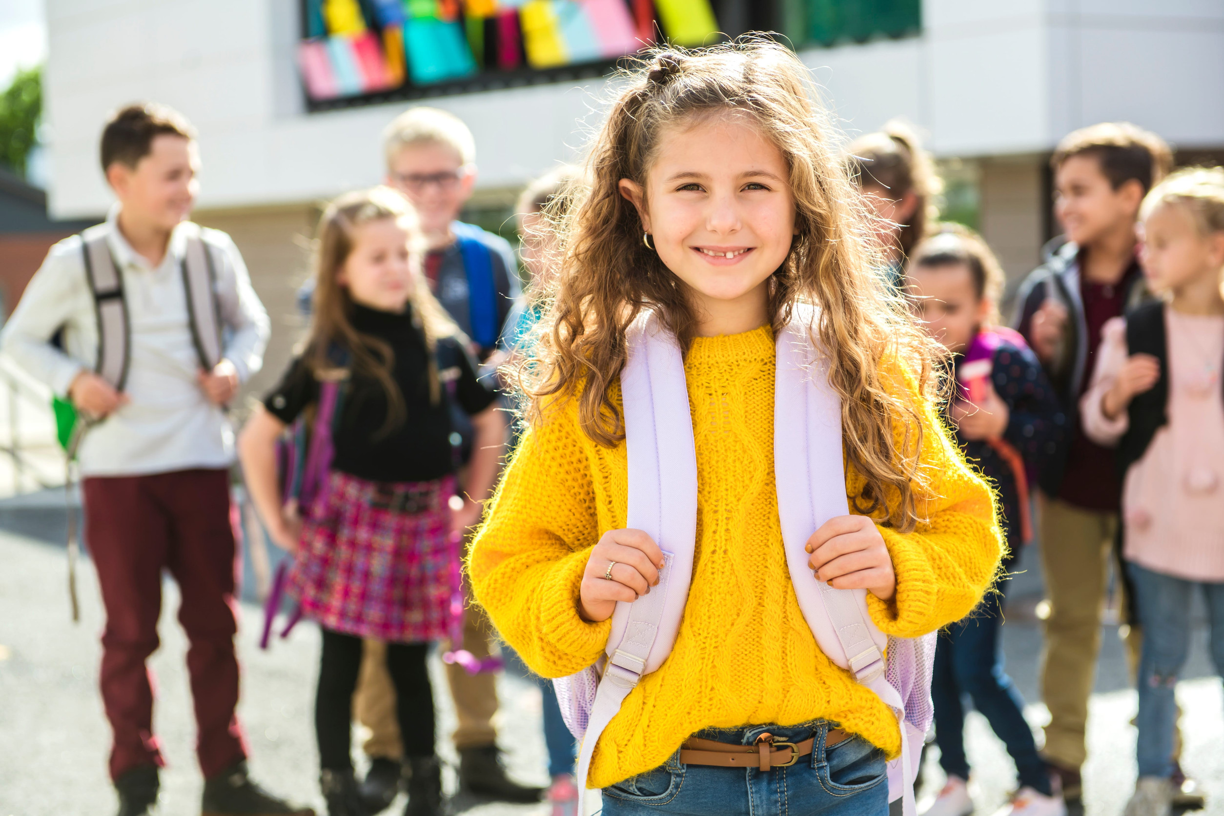 Girl wearing a backpack with her classmates